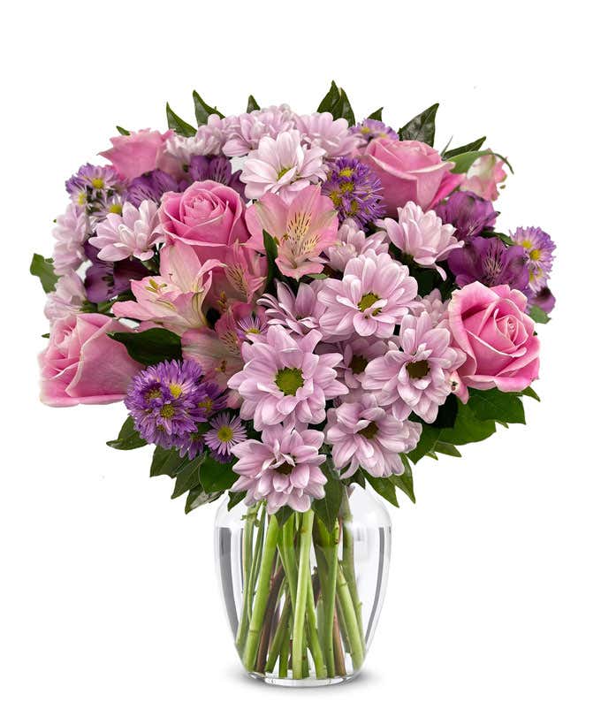 A vibrant arrangement featuring pink roses, purple daisies, pink alstroemeria, purple alstroemeria, and purple Monte Casino, optionally arranged in a vase. This colorful mix offers a cheerful and lively display.