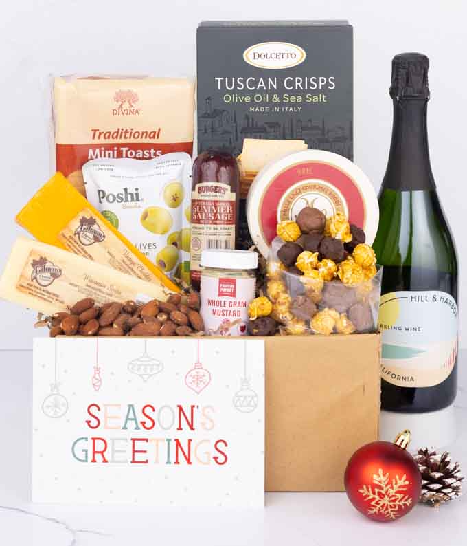 A gift set with a bottle of California Sparkling Wine, focaccia crisps, two cheeses, mustard, summer sausage, caramel popcorn, chocolate pretzels, six chocolate-covered Oreos and a Season's Greetings card to complete the gourmet experience.