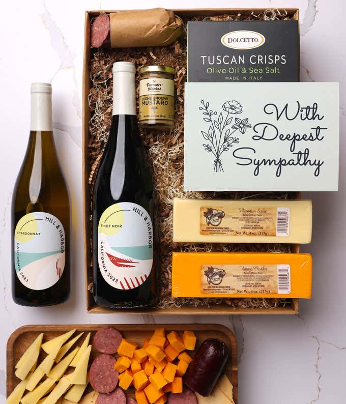 A gift box with two bottles of California wine (Pinot Noir and Chardonnay), two types of cheese, crackers, stone-ground mustard, a summer sausage, and a With Sympathy message card. 