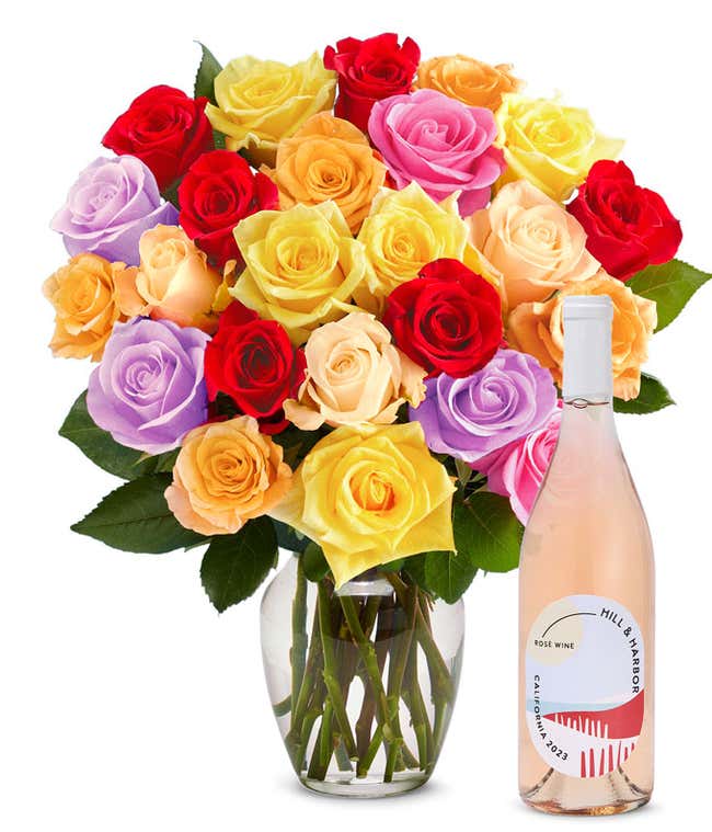 An exquisite bouquet of roses in a kaleidoscope of colors&mdash;vivid reds, soft pinks, warm oranges, sunny yellows, and gentle purples&mdash;arranged in a clear glass vase, accompanied by a sleek bottle of rose wine from California, 2023, embodying grace and festivi