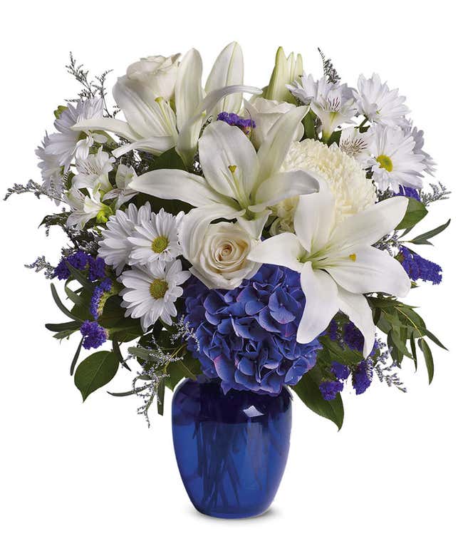 Blue hydrangea, white roses and white oriental lilies in a blue vase