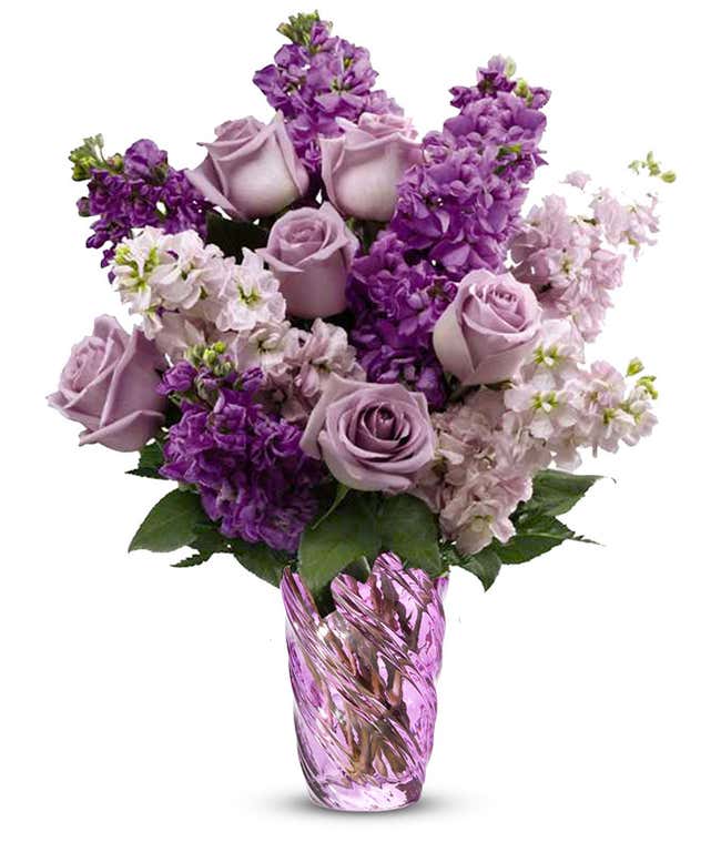 Lavender roses and purple and lavender stock in a purple swirled glass cylinder vase