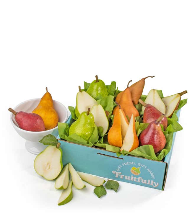 A green box containing three varieties of pears: red, green, and brown, each nestled in green tissue paper, decorated with a green ribbon. 