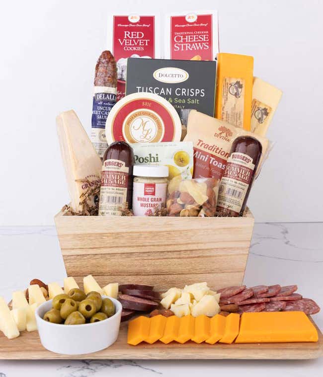 A wooden gift basket filled with summer sausages, 3 cheeses, Tuscan crisps, mini toasts, red velvet cookies, cheese straws, nuts, whole grain mustard, and brie.