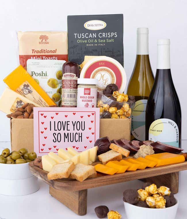 A luxurious gift box with a bottle of Hill &amp; Harbor Pinot Noir, three cheeses, gourmet crackers, summer sausage, marinated olives, smoked almonds, stone-ground mustard, chocolate-covered, and a pink 'I Love You So Much' card