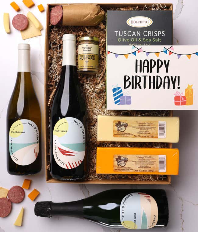 A gift box with three bottles of California wine (red, white, and sparkling), two types of cheese, crackers, stone-ground mustard, a summer sausage, and a festive birthday card.